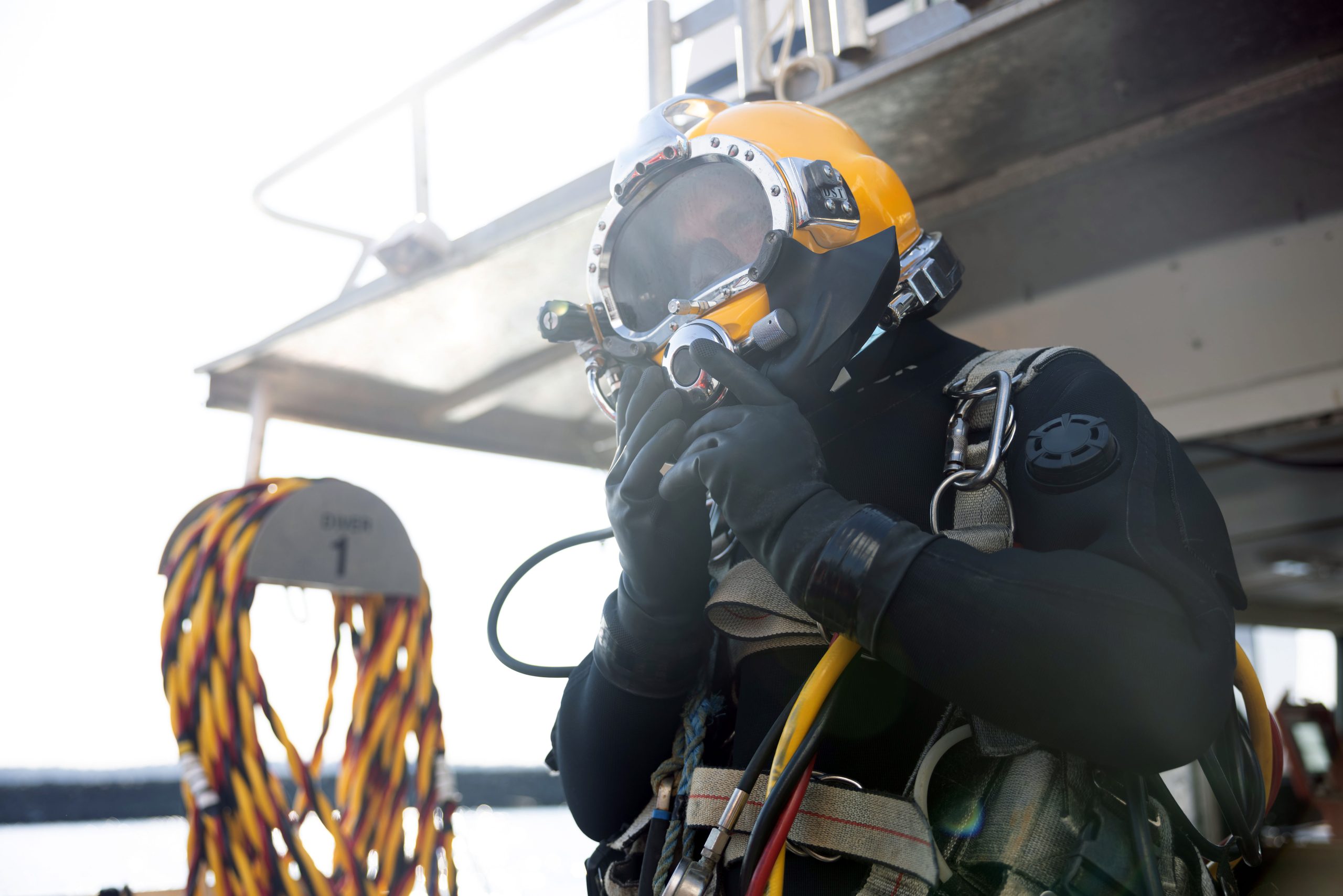 Commercial diver entering water in protective helmet