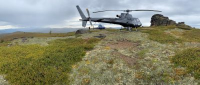 helicopter on grassy open field in the mountains