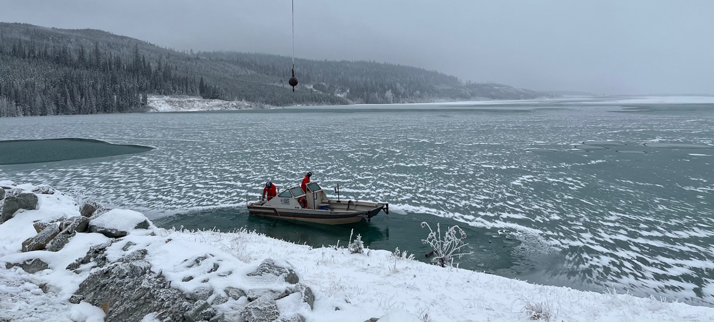 two people in a boat on icy waters in a foggy mountain body of water