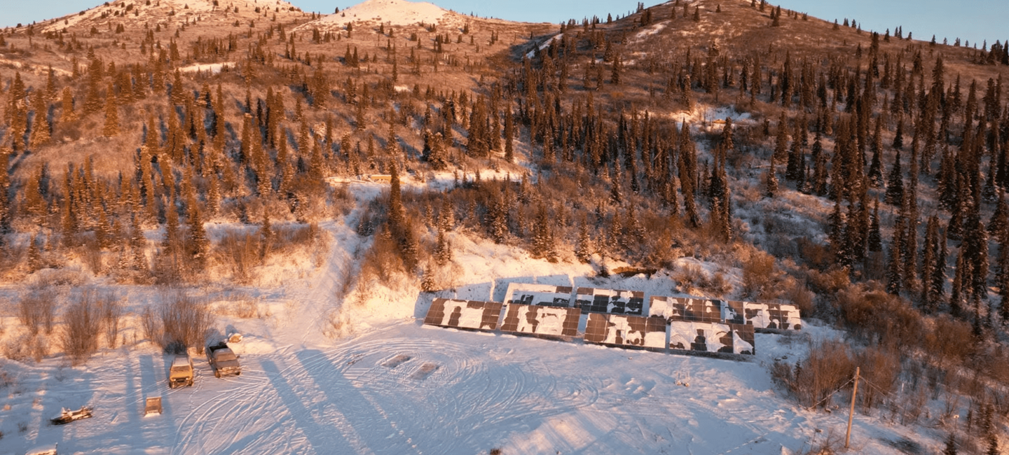 aerial view of project site in snowy mountains with solar panels