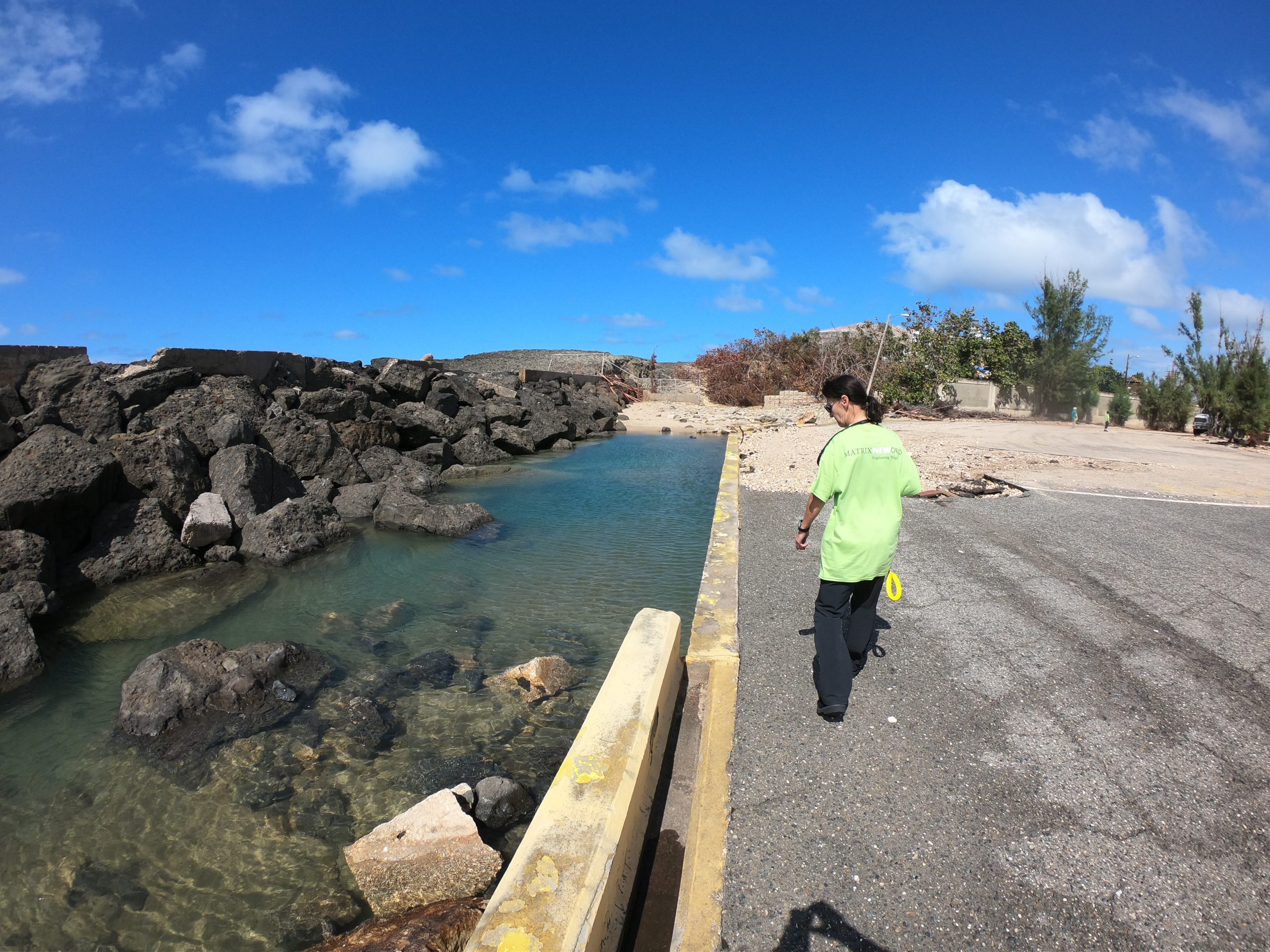 woman on bridge inspecting water