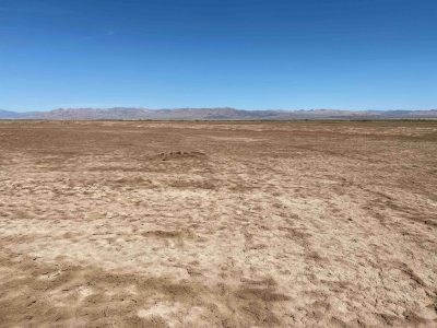 desert dirt and land with mountains in the far distance
