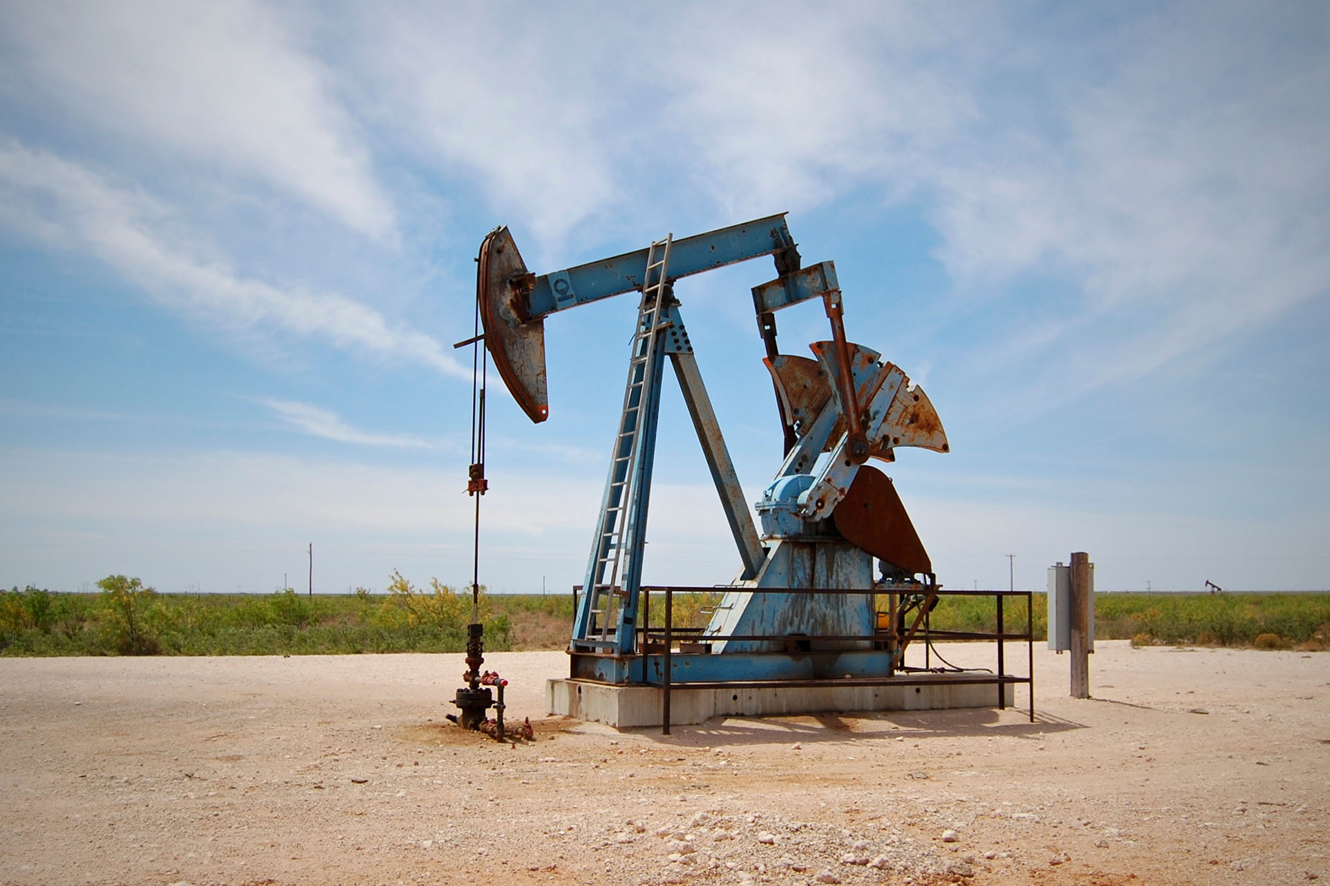 A small pumping unit in the permian basin oilfield painted blue.