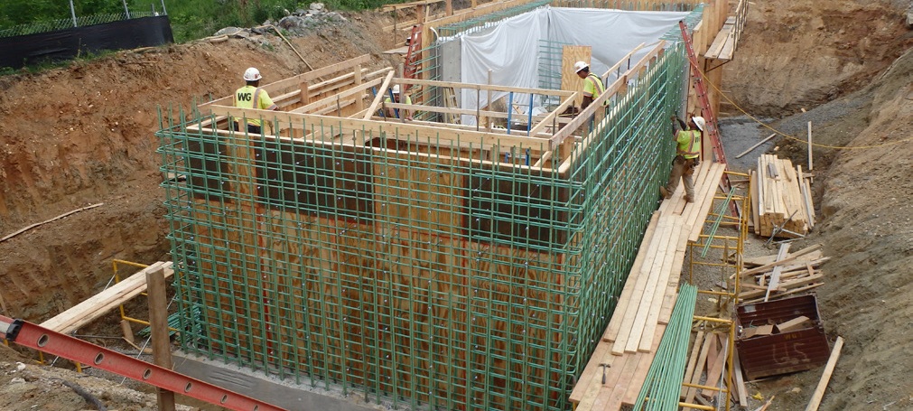 rebar structure in large hole with staff working