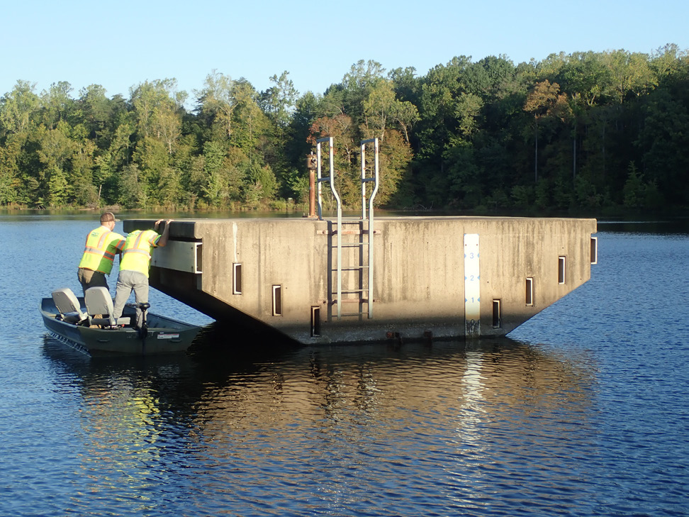 staff conducting inspection of riser structure in body of water