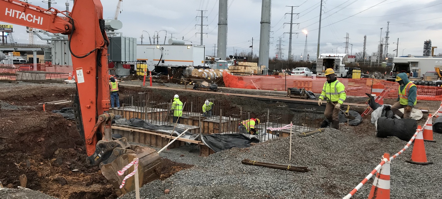 team in large hole with construction equipment