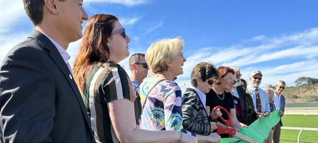 group of people cutting a ribbon