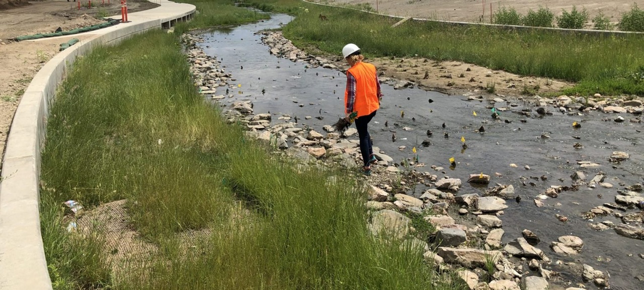 team member in orange vest in stream