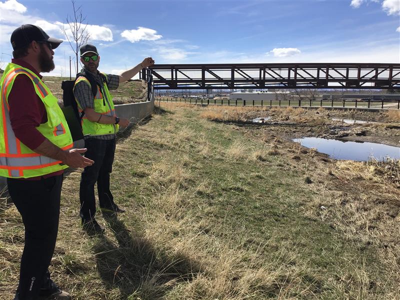 two team members talking at streams edge