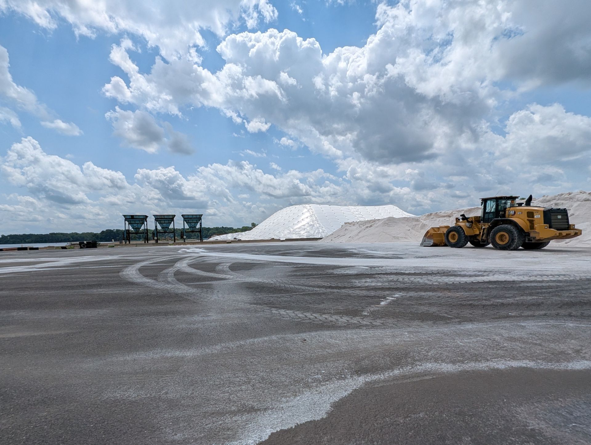 view of salt pile, backhoe, and storage facility equipment