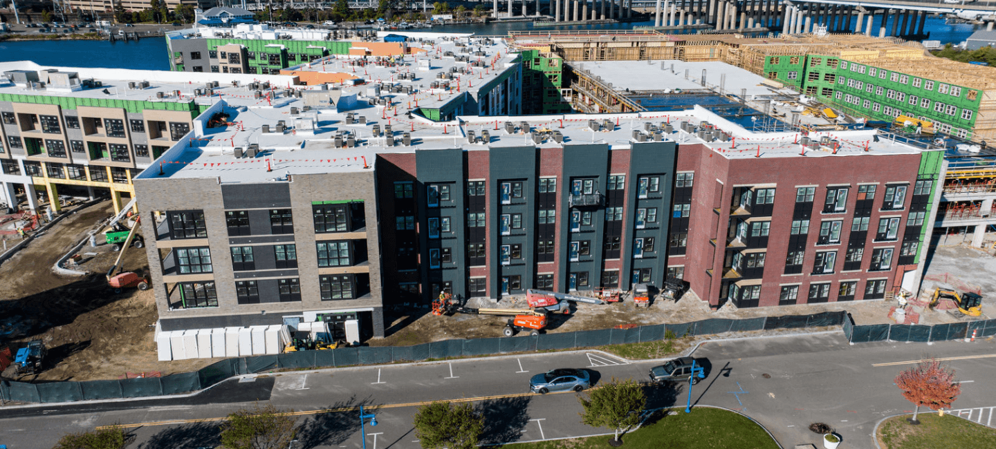 side view of building under construction from street view with river in distance